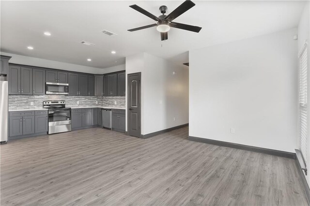 3227 Toledano St, New Orleans, LA 70125 - kitchen with stainless steel appliances, gray cabinets, baseboards, light wood-style flooring, and recessed lighting