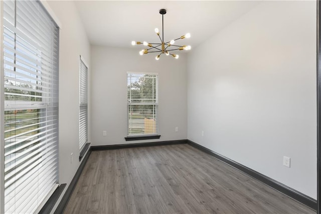 empty room featuring dark hardwood / wood-style flooring and a chandelier