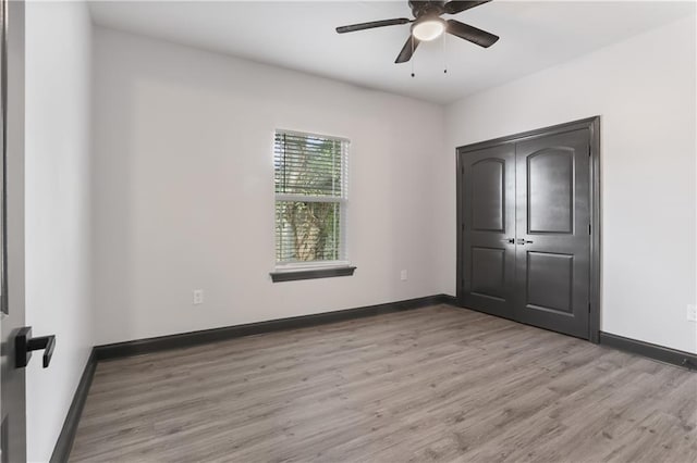 unfurnished bedroom featuring a closet, light wood-type flooring, and ceiling fan