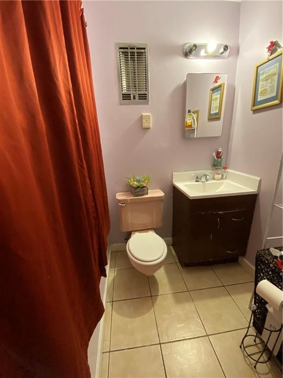 bathroom featuring toilet, vanity, and tile patterned flooring