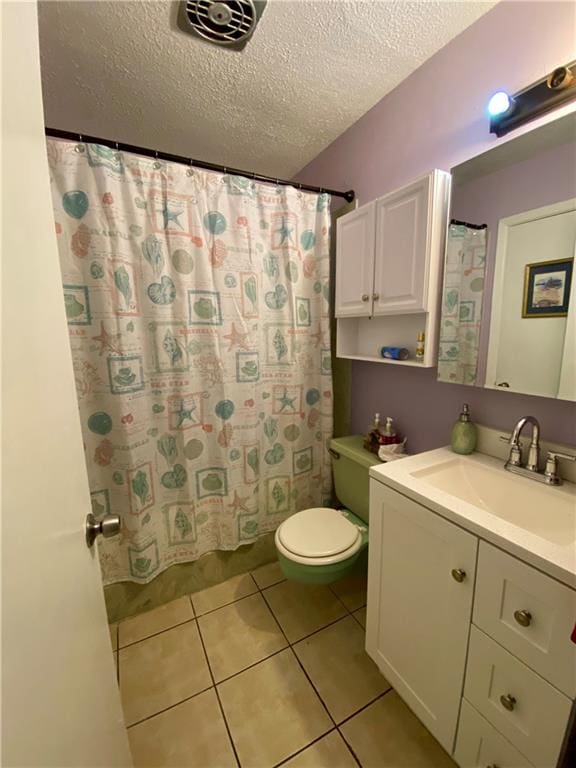 bathroom featuring tile patterned flooring, a shower with shower curtain, a textured ceiling, vanity, and toilet