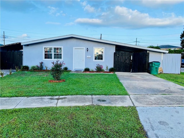 ranch-style home with a carport and a front yard