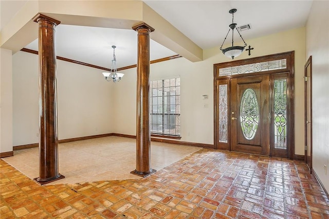 foyer featuring a wealth of natural light, crown molding, and decorative columns