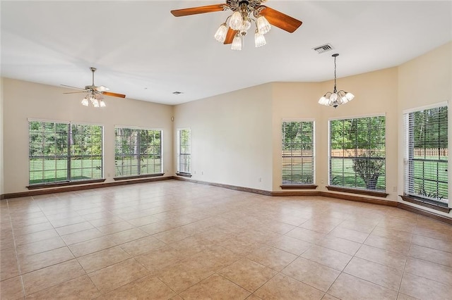 unfurnished room featuring light tile patterned floors and ceiling fan with notable chandelier