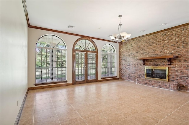 unfurnished living room featuring a brick fireplace, plenty of natural light, crown molding, and a notable chandelier