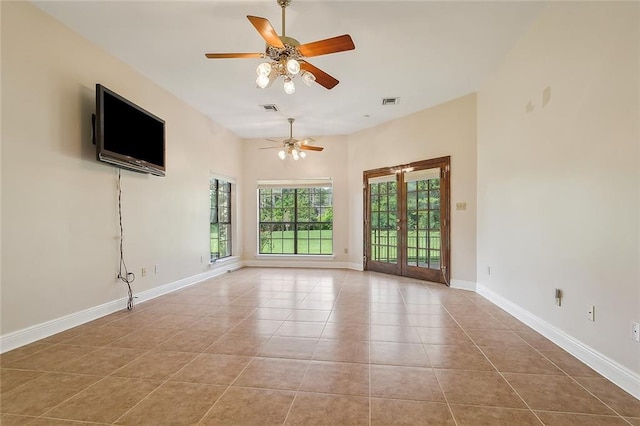 tiled spare room featuring french doors and ceiling fan