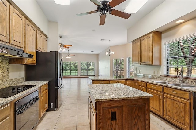 kitchen with a wealth of natural light, black appliances, sink, and a kitchen island