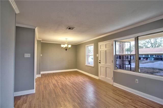 interior space featuring hardwood / wood-style floors, a notable chandelier, and crown molding