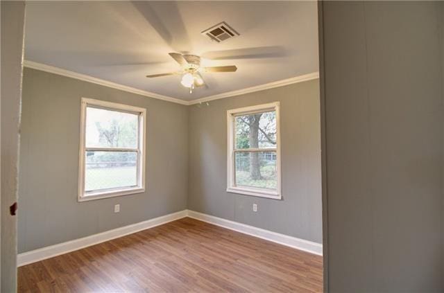 empty room with ornamental molding, wood-type flooring, and ceiling fan