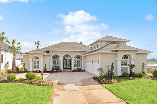 mediterranean / spanish house featuring french doors, a front yard, and a garage