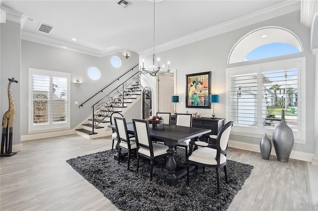 dining space featuring crown molding, a chandelier, and light hardwood / wood-style floors