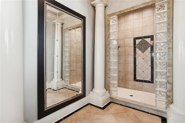 bathroom with decorative columns, a tile shower, and tile patterned floors