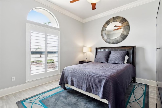 bedroom with hardwood / wood-style floors, crown molding, and ceiling fan