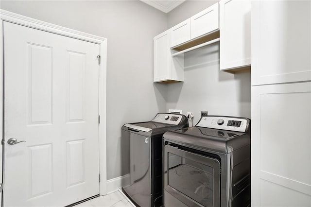 clothes washing area featuring cabinets and washing machine and dryer