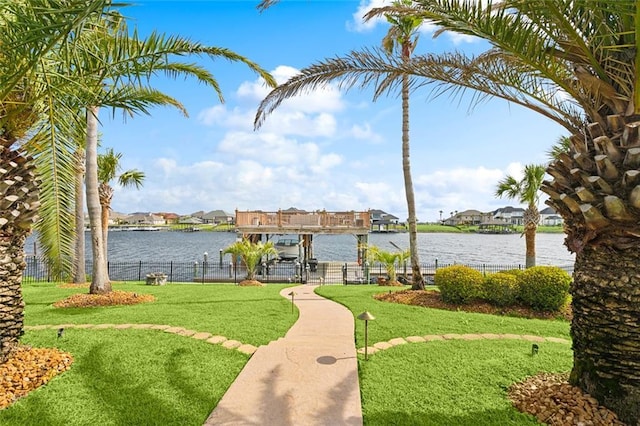 surrounding community with a yard and a water view