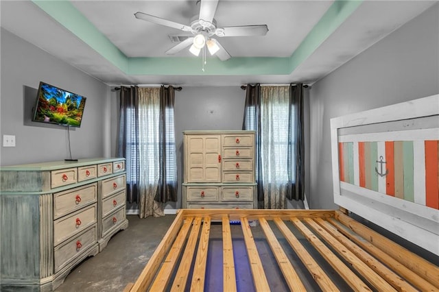 unfurnished bedroom featuring ceiling fan and a raised ceiling