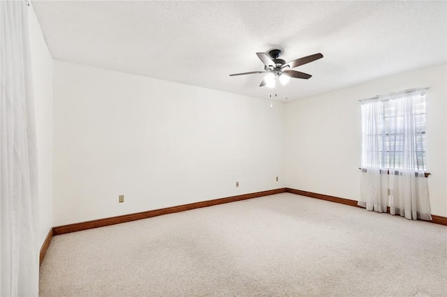 carpeted empty room with ceiling fan and a textured ceiling