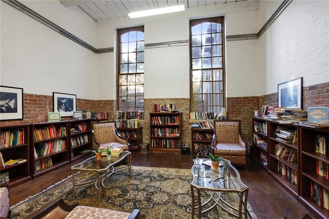 sitting room with wooden ceiling, wood-type flooring, and a high ceiling