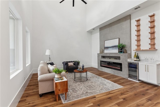 living room featuring ceiling fan, dark hardwood / wood-style flooring, and wine cooler