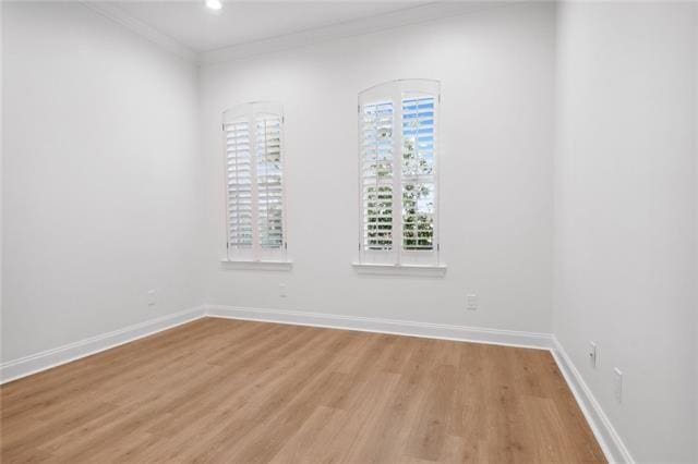 empty room with ornamental molding and light hardwood / wood-style flooring