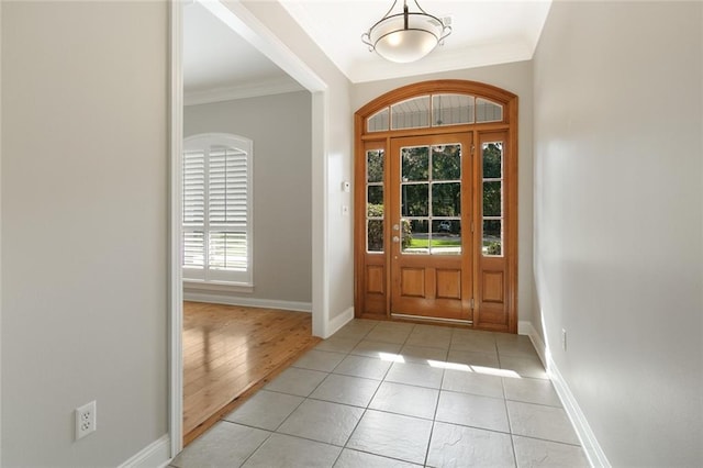 foyer entrance with light hardwood / wood-style flooring and ornamental molding