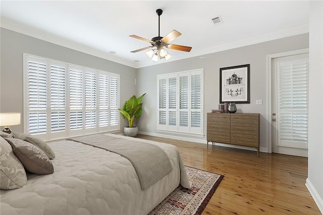 bedroom featuring hardwood / wood-style flooring, ceiling fan, and crown molding