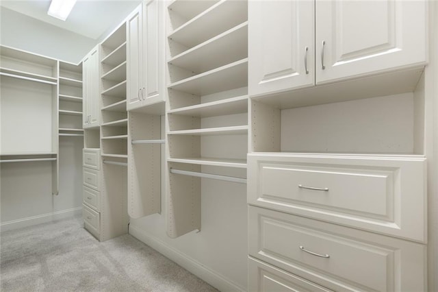 walk in closet featuring light colored carpet