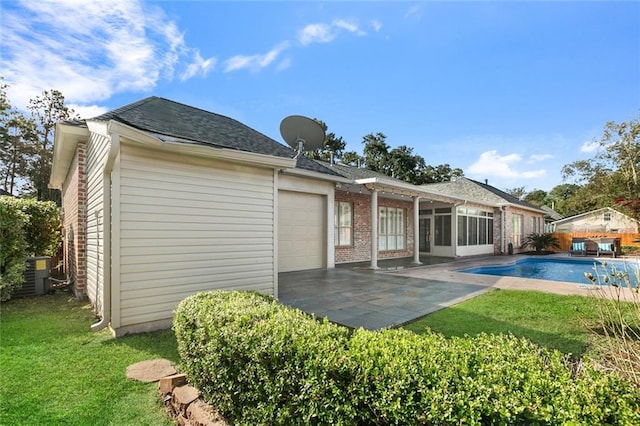 back of property with a yard, a patio area, and central air condition unit