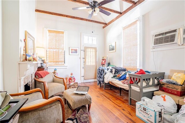 sitting room featuring a wall unit AC, ceiling fan, and light hardwood / wood-style floors