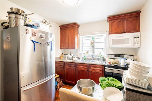 kitchen featuring light stone countertops, appliances with stainless steel finishes, and sink