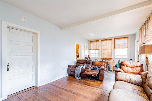 living room featuring beamed ceiling and light wood-type flooring