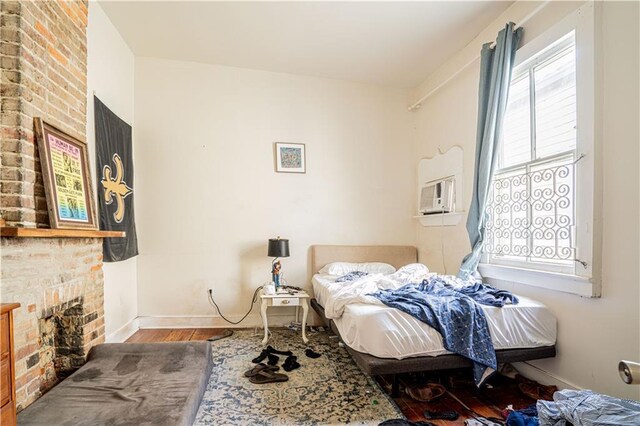 bedroom featuring a fireplace and wood-type flooring