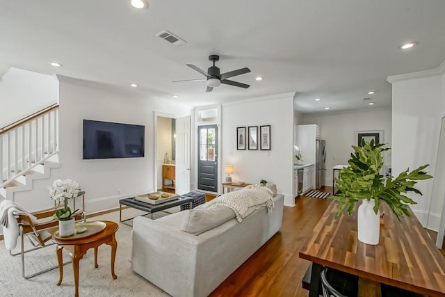 living room featuring hardwood / wood-style floors, ceiling fan, and crown molding