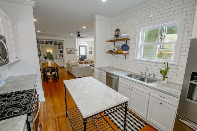 kitchen with stainless steel appliances, white cabinetry, dark hardwood / wood-style flooring, light stone countertops, and sink