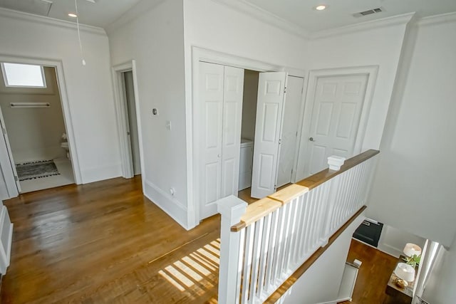 hall with dark wood-type flooring and ornamental molding