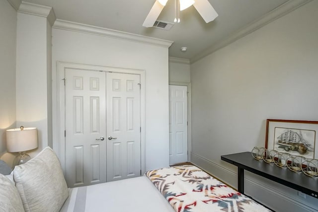 bedroom featuring ceiling fan, crown molding, and a closet