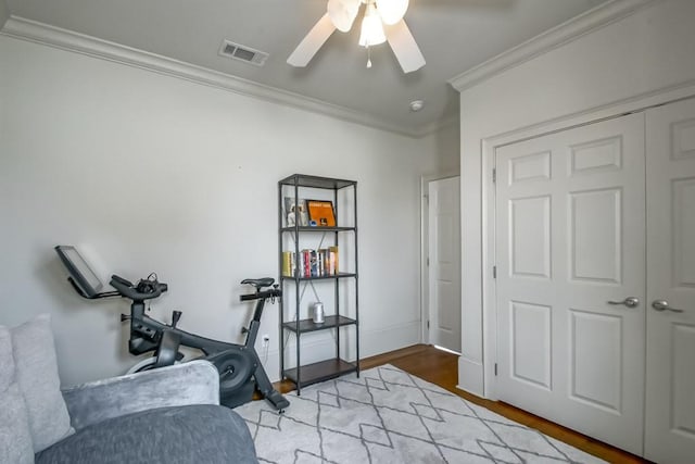 sitting room with light hardwood / wood-style floors, ceiling fan, and crown molding