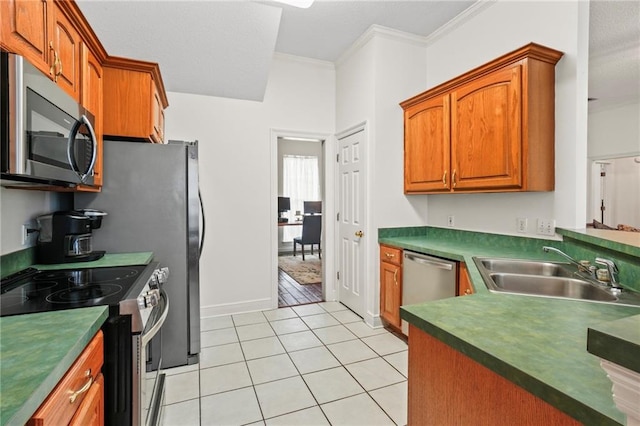 kitchen featuring ornamental molding, appliances with stainless steel finishes, sink, and light tile patterned floors