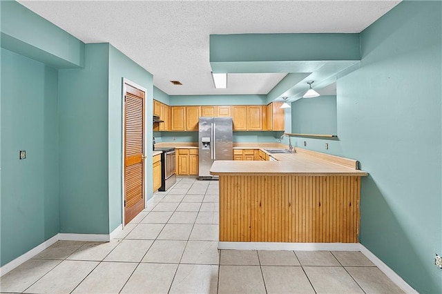 kitchen featuring kitchen peninsula, a textured ceiling, sink, electric range, and stainless steel fridge