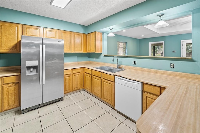 kitchen featuring light tile patterned flooring, a textured ceiling, stainless steel refrigerator with ice dispenser, sink, and dishwasher