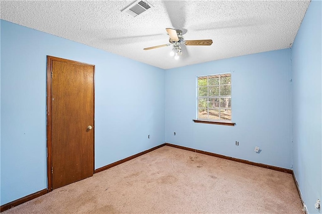 carpeted empty room with ceiling fan and a textured ceiling