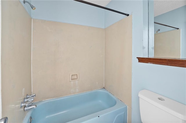 bathroom with a textured ceiling, toilet, and bathing tub / shower combination