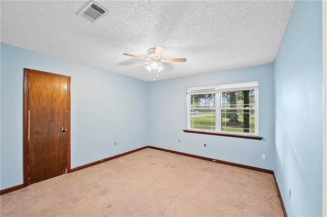 unfurnished room featuring ceiling fan, a textured ceiling, and light carpet