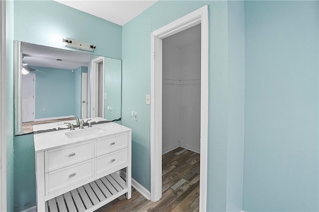 bathroom with hardwood / wood-style flooring, ceiling fan, and vanity