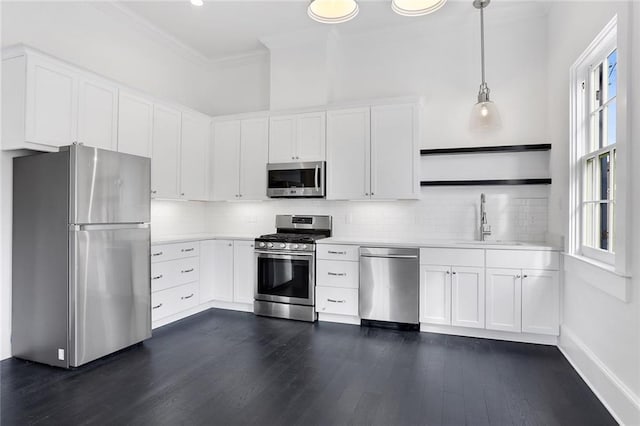 kitchen with hanging light fixtures, a wealth of natural light, sink, and appliances with stainless steel finishes