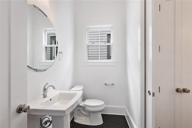 bathroom featuring toilet, sink, and tile patterned flooring