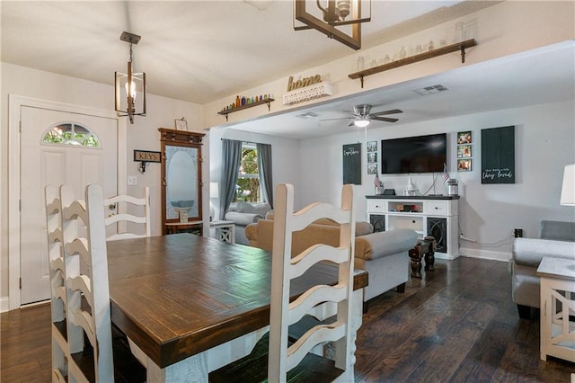 dining area with dark wood-type flooring and ceiling fan with notable chandelier