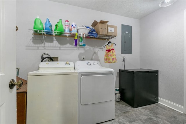 washroom featuring electric panel, a textured ceiling, and washer and dryer