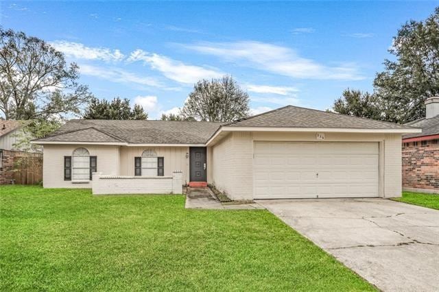 ranch-style house with a garage and a front lawn