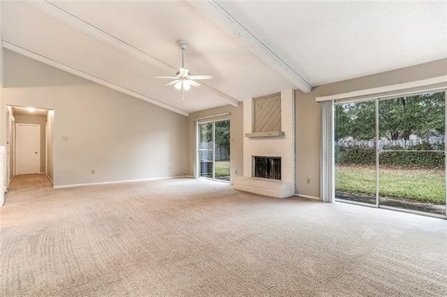 unfurnished living room featuring vaulted ceiling with beams, light colored carpet, ceiling fan, and a large fireplace